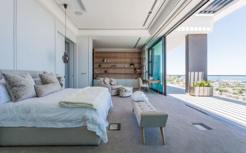 Beach Resort Villa Bedroom Comfortable Lounge Chair with Ottoman with Leather Top Desk and Wood Shelves Mounted on Wall and Sideboard